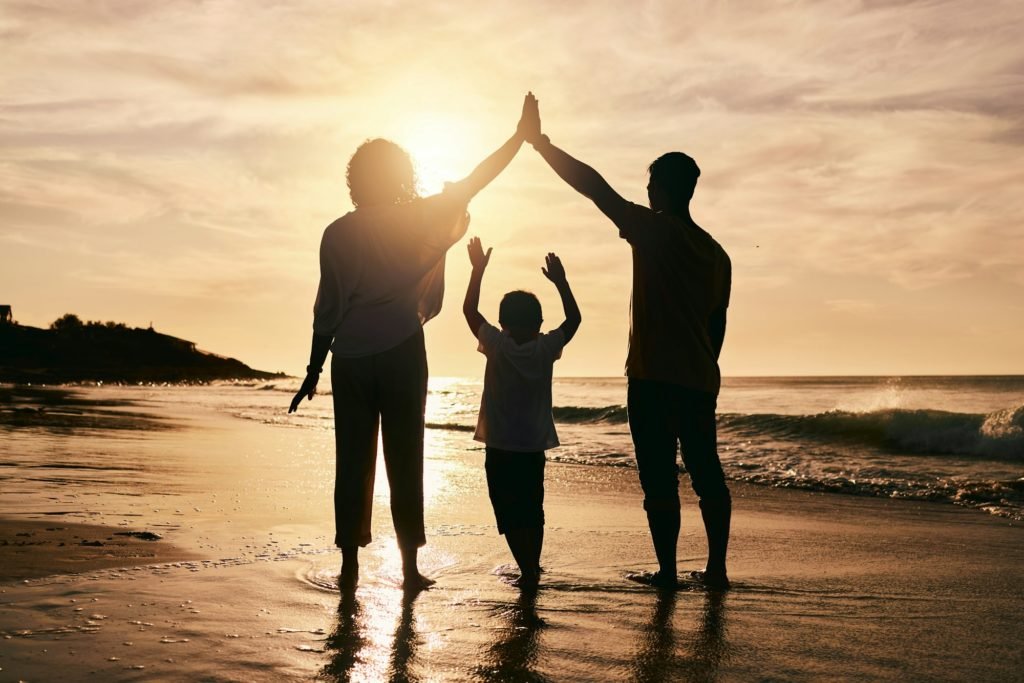 Silhouette, family and safety, beach and back view with parents and child, protection and ocean wav